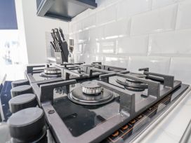 A gas stove with knobs and kitchen utensils at 2 bed in Scarborough