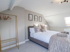 A bedroom with a bed and clothes rack at 2 bed in Scarborough