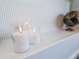 Candles and a globe on a shelf in a living room at 2 bed Scarborough