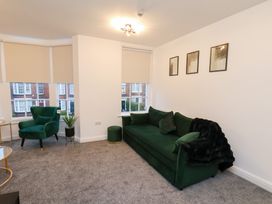 A living room with a green sofa and armchair at Maxwell View, Scarborough
