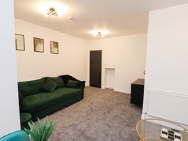 A living room with a green sofa and a black door at Maxwell View in Scarborough