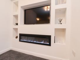 A living room with a television and electric fireplace at Maxwell View in Scarborough