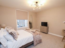 A bedroom with a bed and television at Maxwell View in Scarborough