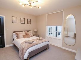 A bedroom with a bed, mirror, and window at Maxwell View in Scarborough
