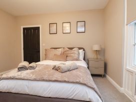 A bedroom with bed, nightstand, lamp, and door at Maxwell View in Scarborough