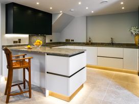 A kitchen with a countertop and bar stool at The School House in Newton Abbot