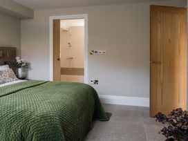 A bedroom with a bed and an attached shower at The School House in Newton Abbot