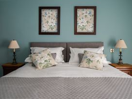 A bedroom with a bed and wall art at The School House in Newton Abbot