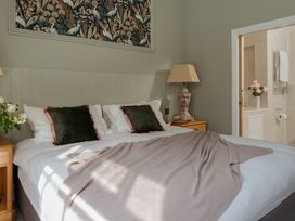 A bedroom with a bed and flowers on a bedside table at Upper School House in Newton Abbot