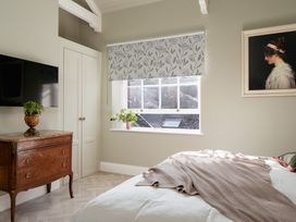 A bedroom with a window and television at Upper School House in Newton Abbot