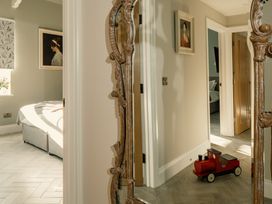 A hallway with a mirror, artwork, and a toy train at Upper School House Newton Abbot