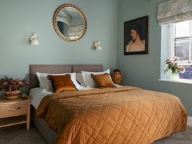 A bedroom with a bed and decorative items at Upper School House Newton Abbot
