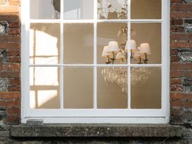 A window with a chandelier visible from outside at Upper School House in Newton Abbot
