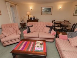 A living room with sofas and a dining table at Grange Cottage in Belford