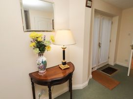 A hallway with a table and lamp at Grange Cottage in Belford