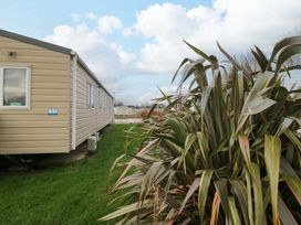 An outdoor view of a mobile home and plants at 62 Guddlebeck in Flookburgh