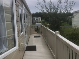 A pathway with a car and surrounding greenery at 62 Guddlebeck in Lakeland Leisure Park, Flookburgh