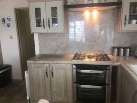 A kitchen with cabinets, gas stove, and oven at 62 Guddlebeck, Lakeland Leisure Park, Flookburgh