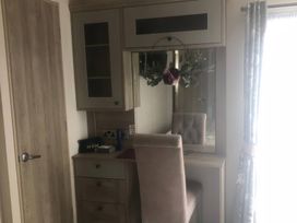 A bedroom with a desk and mirror at 62 Guddlebeck, Lakeland Leisure Park, Flookburgh