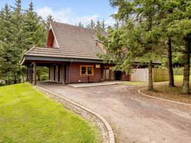 A house with a sloped roof and trees around at Foresters Spa Plus Dundee