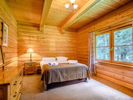 A bedroom with a bed, lamp, and window at Foresters Spa Plus in Dundee