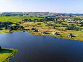 A view of houses near a lake with fields and trees at Foresters Spa Plus in Dundee