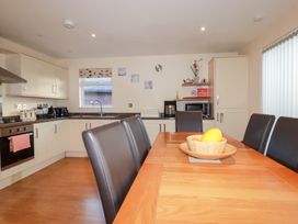 A kitchen with a dining table and chairs at 65 Benasa Lodge near St Columb Major