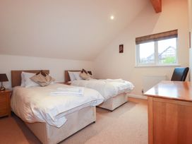 A bedroom with two beds and a desk at 65 Benasa Lodge, Winnard's Perch near St Columb Major