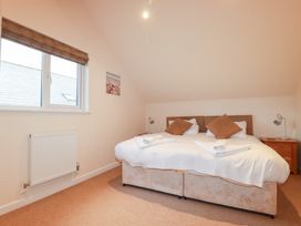 A bedroom with a double bed and nightstand at 65 Benasa Lodge, Winnard's Perch near St Columb Major