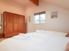 A bedroom with a wardrobe and towels on the bed at 65 Benasa Lodge in Winnard's Perch near St Columb Major