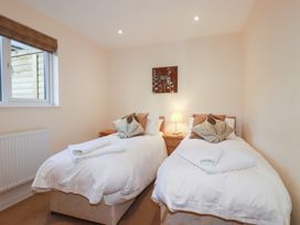 A bedroom with twin beds and a lamp at 65 Benasa Lodge near St Columb Major