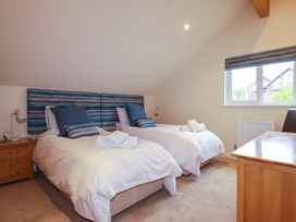 A bedroom with two beds and a desk at 65 Benasa Lodge, Winnard's Perch near St Columb Major