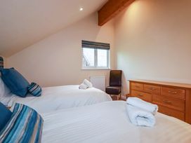 A bedroom with two beds and a window at 65 Benasa Lodge, Winnard's Perch near St Columb Major