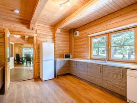 A kitchen with refrigerator, sink, and cabinets at Foresters Spa Plus (Pet) Dundee
