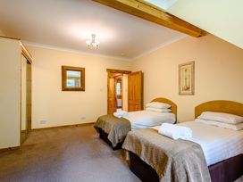 A bedroom with two beds and a mirror at Foresters Spa Plus (Pet) in Dundee