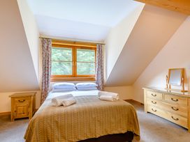 A bedroom with a bed and windows at Foresters Spa Plus (Pet) in Dundee