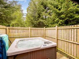 A hot tub in a garden area surrounded by a wooden fence at Eagle Spa Plus (Pet) Dundee
