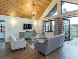 A living room with furniture and a television at Byron Premier Spa in Dundee