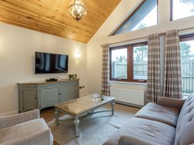 A living room with a television and coffee table at Byron Premier Spa in Dundee