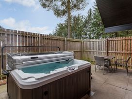 An outdoor area with a hot tub and seating at Byron Premier Spa in Dundee
