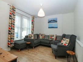 A living room with a sofa and cushions at Mona Lodge in Llandudno