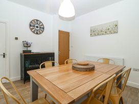 A dining room with a wooden table and chairs at Mona Lodge in Llandudno