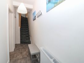 A hallway with a bench and stairs at Mona Lodge in Llandudno