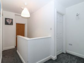 A hallway with a door and light fixture at Mona Lodge in Llandudno