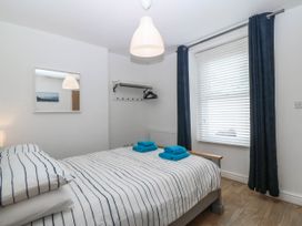 A bedroom with a bed and mirror at Mona Lodge in Llandudno