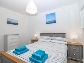A bedroom with a bed and dresser at Mona Lodge in Llandudno