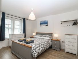 A bedroom with a bed, bedside table, and dresser at Mona Lodge in Llandudno