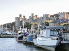 A marina with boats and a castle in the background at Mona Lodge in Llandudno