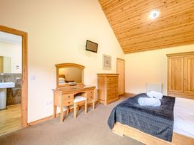 A bedroom with a bed, dresser, and wardrobe at Muirloch Spa Plus, Dundee