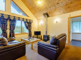 A living room with a sofa and television at Muirloch Spa Plus (Pet) Dundee